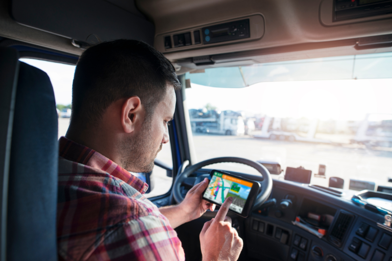 Un șofer de camion setează destinația pe GPS.